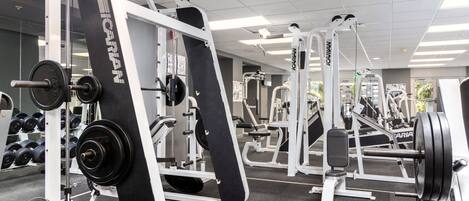 A gym with various weightlifting equipment, including barbells and weight plates.