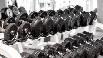 A rack of black dumbbells in a gym.