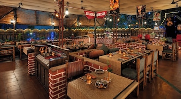 Ein Restaurant mit Ziegelwänden, Holzmöbeln und einer Bar.