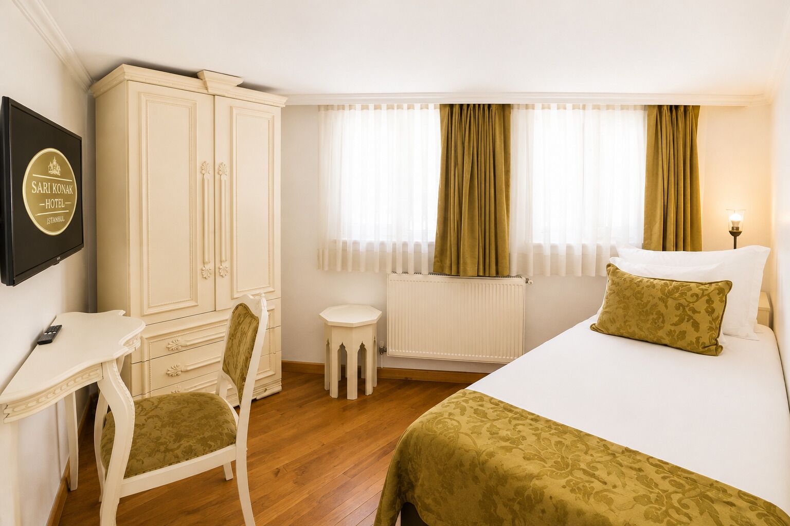 Ein Hotelzimmer mit Bett, Schreibtisch, Stuhl, Kleiderschrank und Heizkörper.