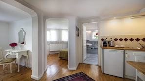 A compact kitchen with a refrigerator, sink, and a small dining area.