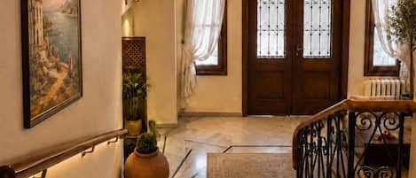 A staircase with a handrail, a door with glass panels, and a chandelier.