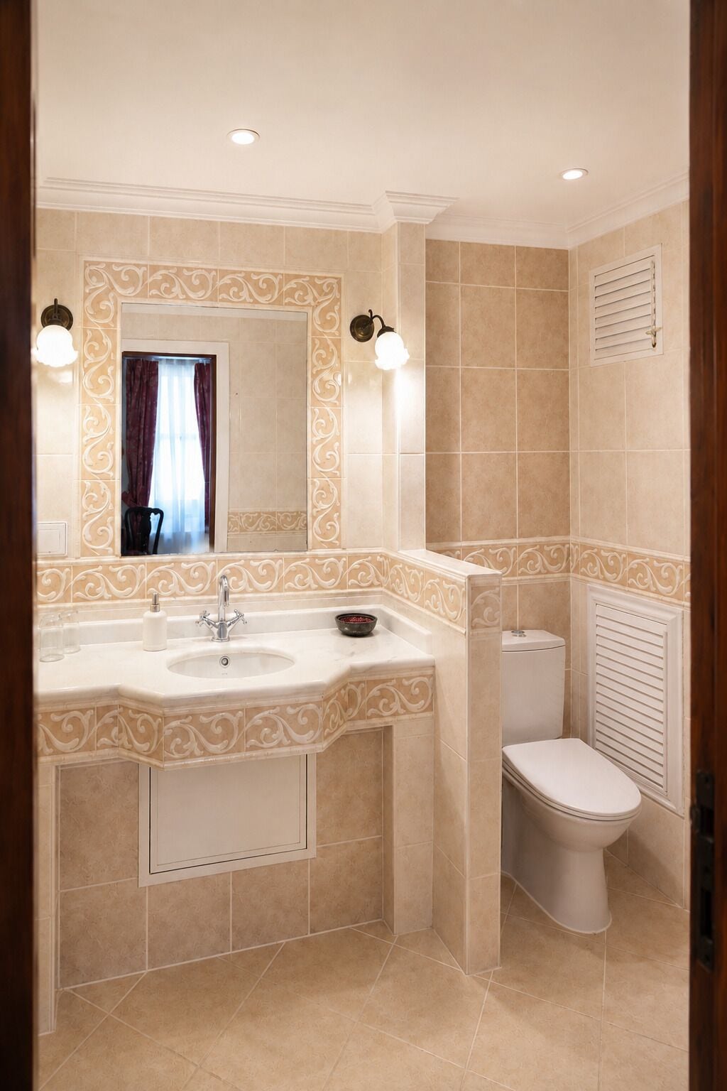 A bathroom with a double sink, a toilet, and a mirror with decorative wall tiles.