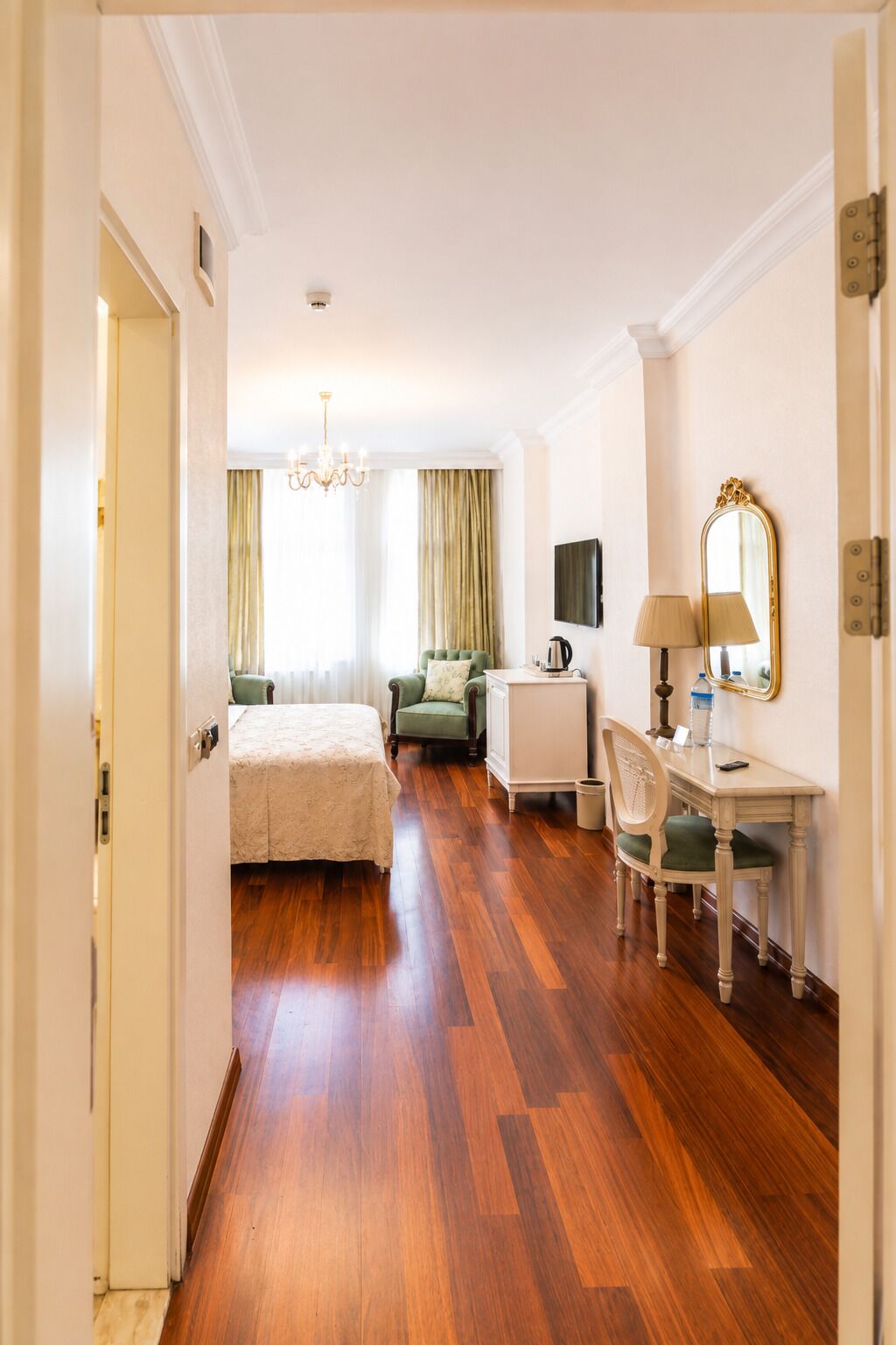 Une chambre d’hôtel comprenant un lit, un bureau, une chaise, une télévision et un miroir.