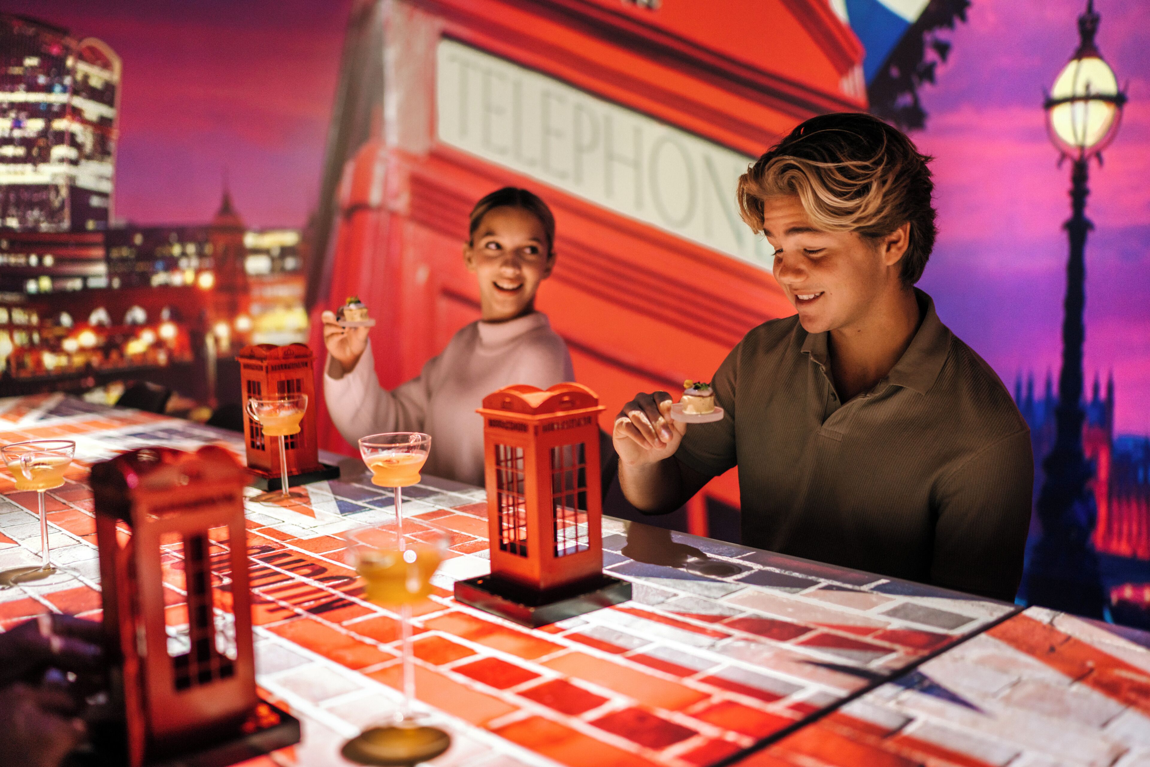 Una mesa con caballete rojo como centro de mesa, un fondo de paisaje urbano y un farol.