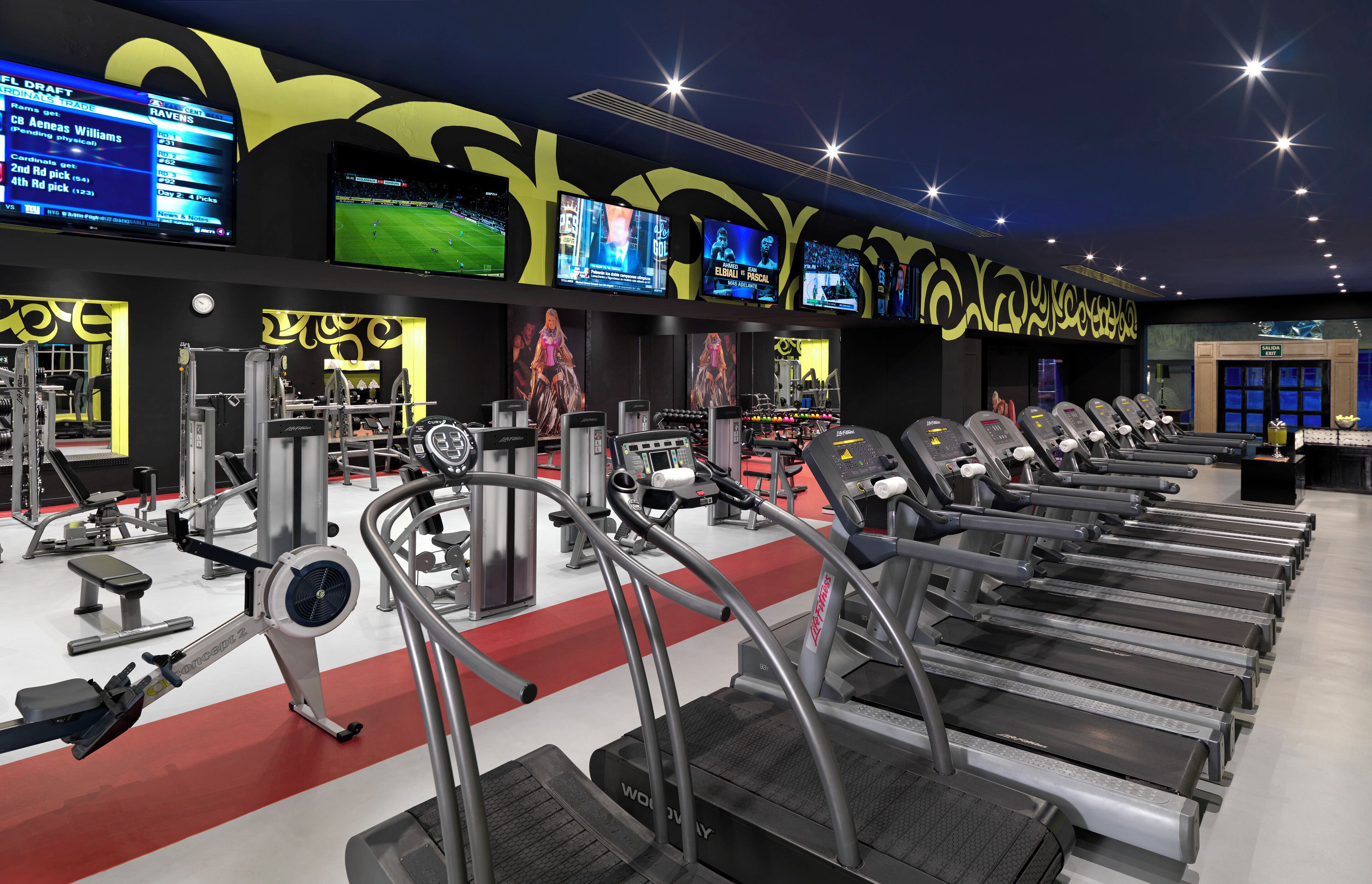 A gym with treadmills, weight machines, and exercise balls.