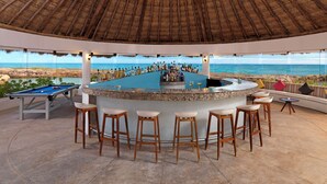 A bar area with a pool table, bar stools, and a view of the ocean. - Hard Rock Hotel Riviera Maya -  All Inclusive (Puerto Aventuras)