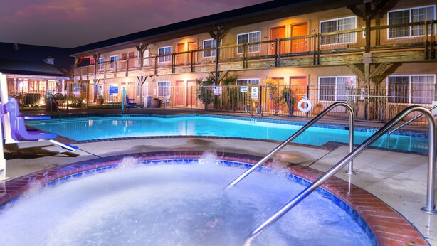 A hotel with a swimming pool, a hot tub, and a covered deck area. - Days Inn by Wyndham Lebec (Lebec)
