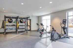 A gym with exercise equipment, including a pull-up bar, an elliptical, and a stationary bike. - Hilton Garden Inn Denver Tech Center (Denver)