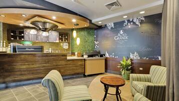 Interior de uma cafeteria com balcão, área de estar e cardápio.