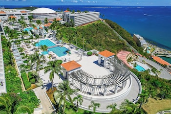 An aerial view of a coastal area with a beach, boats, and clear blue waters. at El Conquistador Resort