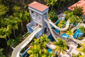 A resort with a water slide, a pool, and lush greenery. - El Conquistador Resort (Fajardo)