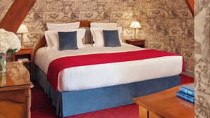 Une chambre à coucher avec un grand lit, une moquette rouge et un papier peint à motifs.