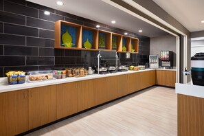 Une cuisine moderne dotée d’un long comptoir, de meubles en bois et d’une variété de produits alimentaires exposés.