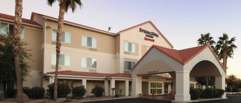 A hotel with a clear entrance, multiple floors, and a red-tiled roof.