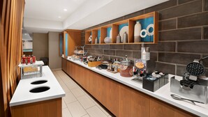 Un bar à petit-déjeuner moderne proposant une variété d'aliments et une machine à gaufres.