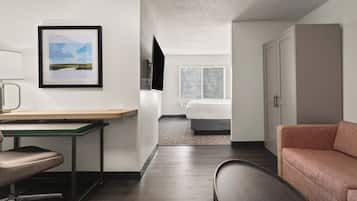 Una habitación de hotel moderna con escritorio, silla, cama y sofá.