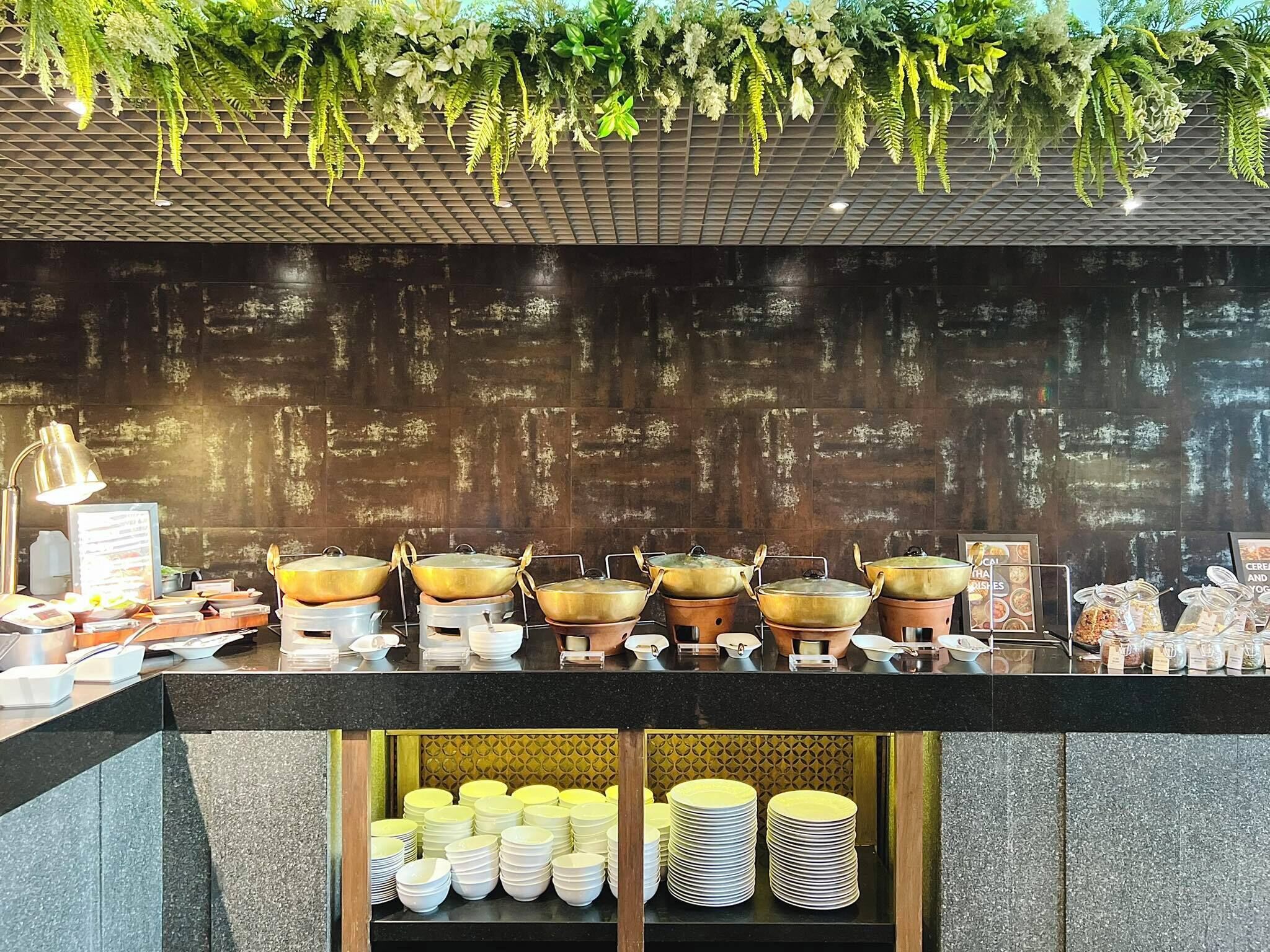 A buffet setup with multiple serving stations, including pots and bowls, and a variety of food items.