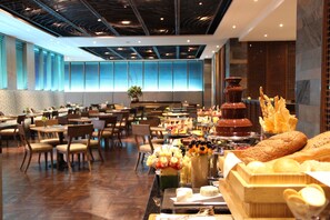 Enjoy a meal in our dining area, featuring a buffet with a variety of options and comfortable seating.
