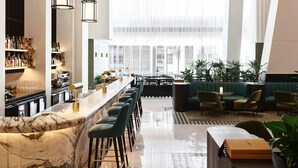A modern bar area with marble countertops, bar stools, and a variety of bottles and glasses. - Swissotel Sydney (Sydney)