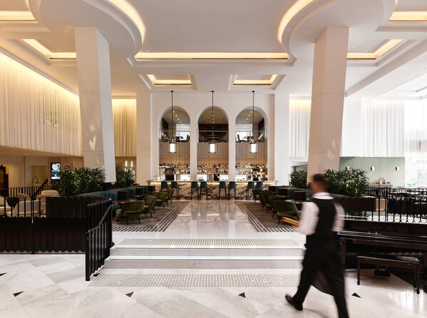 A spacious lobby with a bar area, seating arrangements, and a piano. - Swissotel Sydney (Sydney)