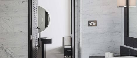 A modern bathroom with a white bathtub, a large mirror, and a black vanity.