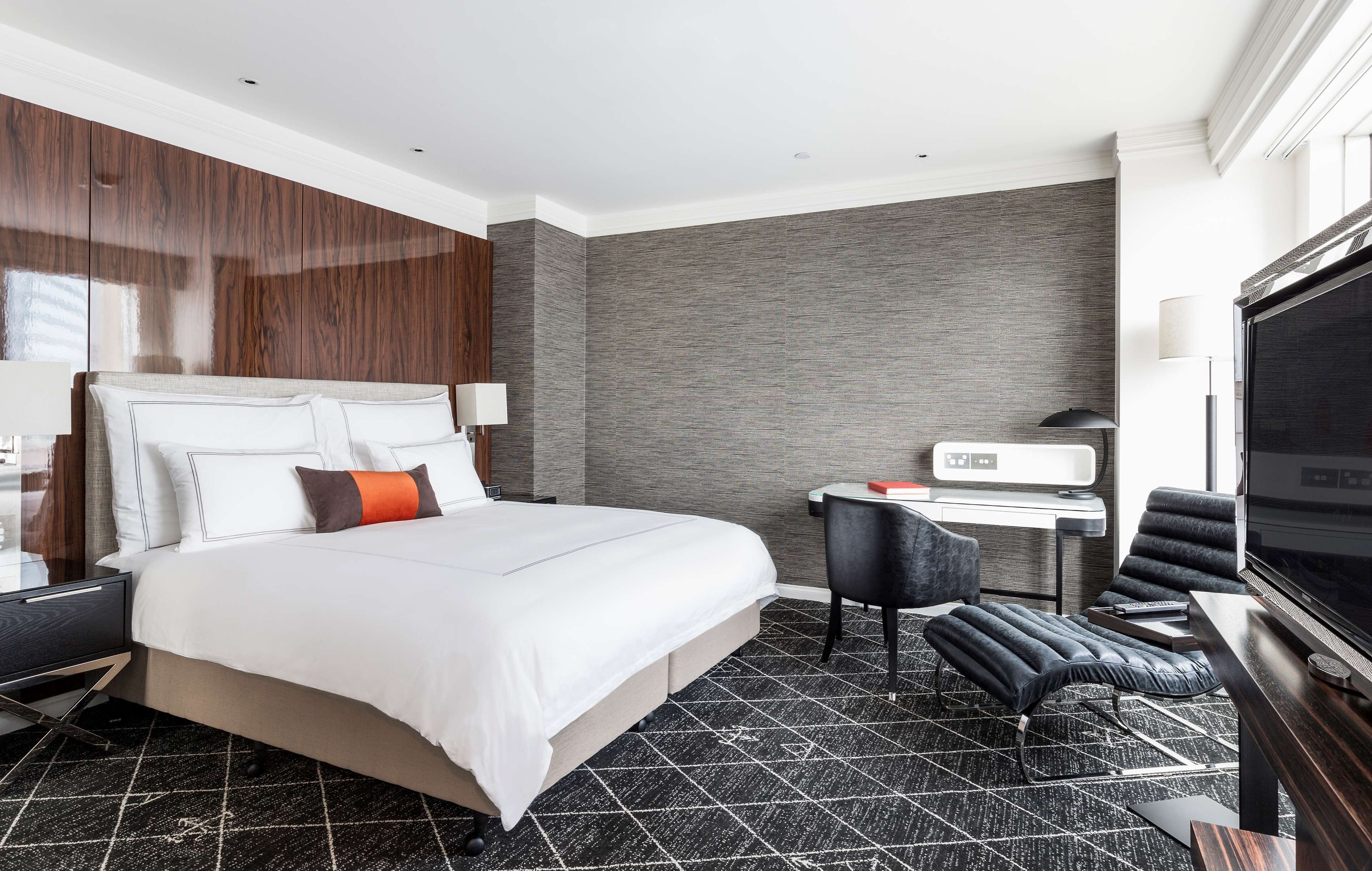 Une chambre d’hôtel moderne dotée d’un grand lit, d’un bureau, d’une télévision et d’un coin salon.