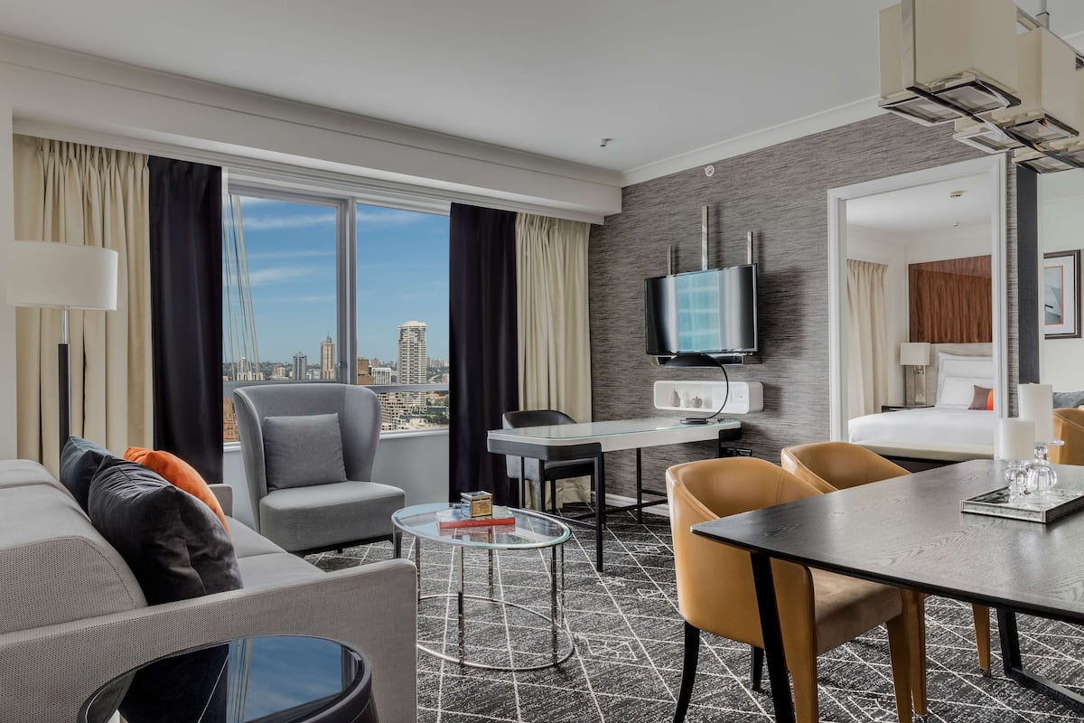 Una habitación de hotel moderna con vistas a la ciudad, un comedor y una sala de estar.