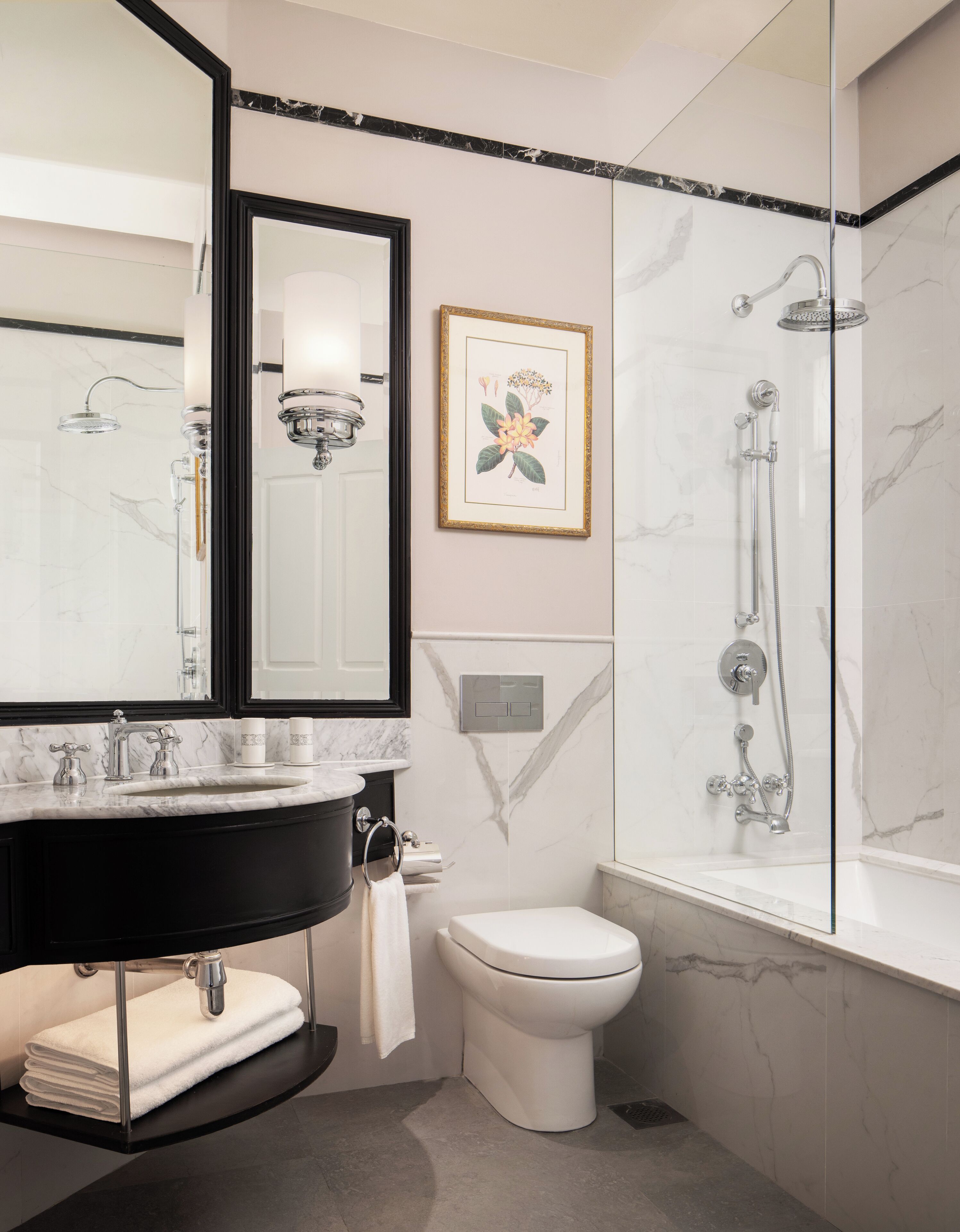A modern bathroom with a black vanity, white toilet, and a glass-enclosed shower.