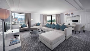 A modern hotel room with a large sofa set, a dining table, and a city view. - Paradox Singapore (Singapore)