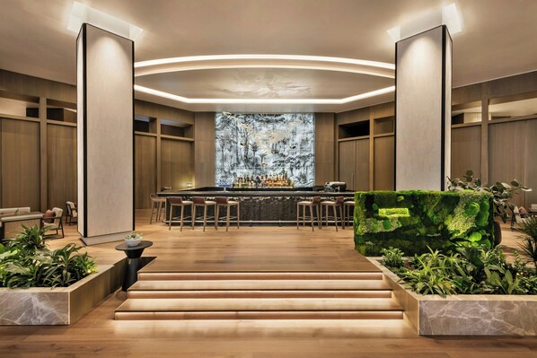 A modern bar area with a central island, wooden flooring, and a seating arrangement. - JW Marriott Auckland (Auckland)