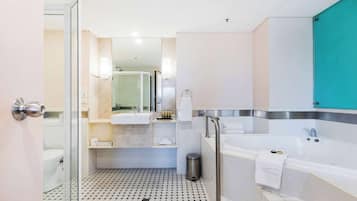 Un bany modern amb una cabina de dutxa de vidre, una banyera i un vàter.
