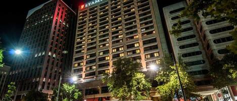 A high-rise hotel with a prominent "STAMFORD" sign, multiple floors, and a modern architectural design.