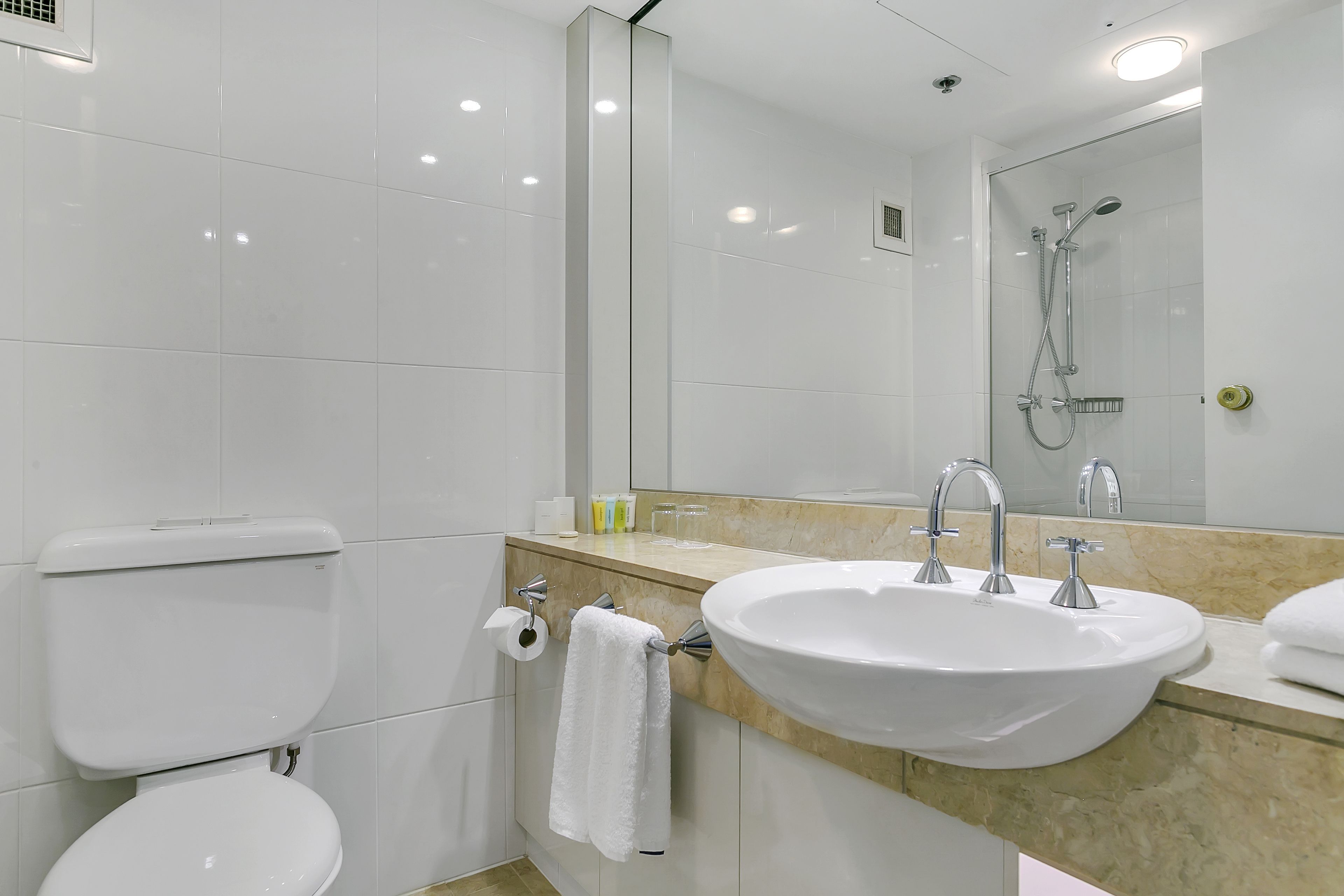Une salle de bain moderne équipée de toilettes, d’un lavabo et d’une douche.