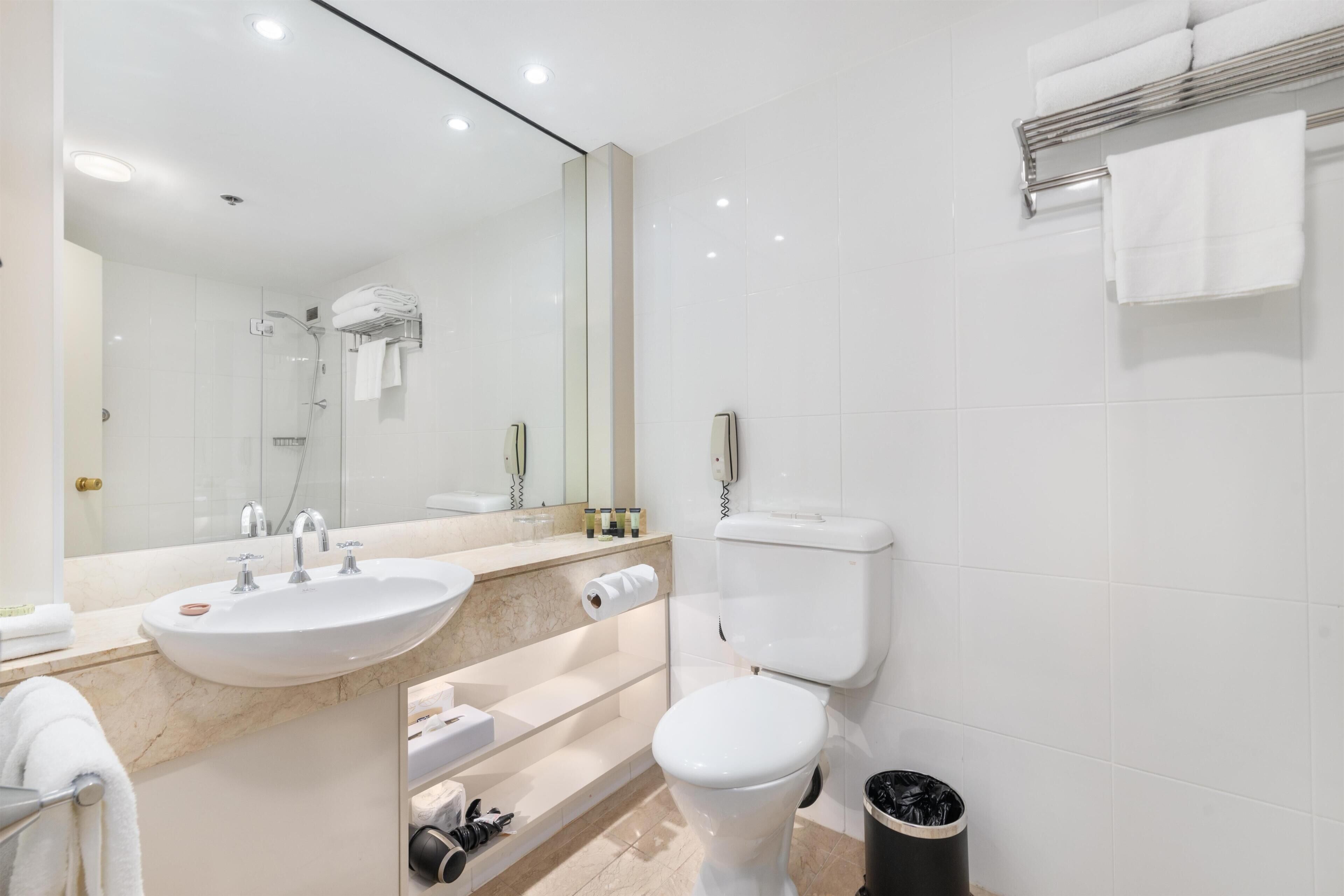 A modern bathroom with a sink, toilet, and shower.