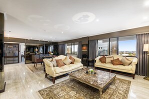A spacious living area with two sofas, a coffee table, and a view of the city. - Stamford Plaza Adelaide (Adelaide)