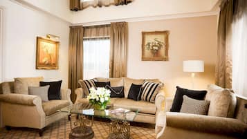 A living room with a sofa set, a glass coffee table, and two wall-mounted lamps.