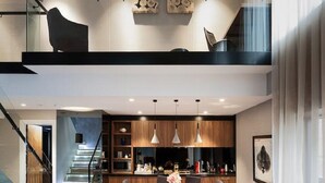 Un interior moderno con sofá, comedor y escalera.