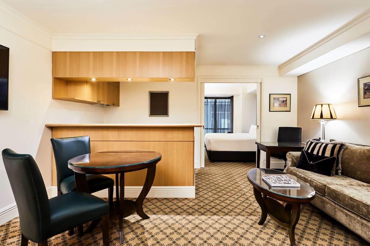 Une chambre d’hôtel comprenant un coin repas, un canapé, une lampe et un lit.