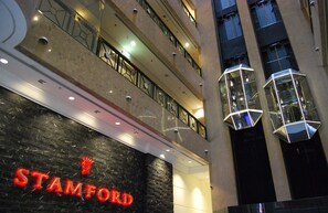 A multi-story building with a prominent 'STAMFORD' sign, balconies, and modern geometric light fixtures.