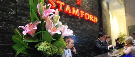 A reception desk with a floral arrangement and a neon sign reading "STAMFORD".