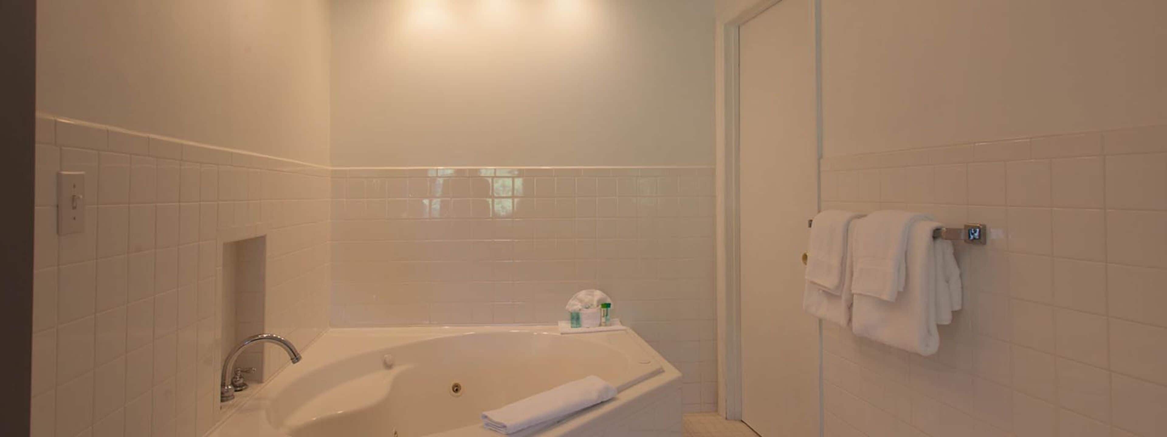 Un baño con bañera, toallero y zona de ducha.
