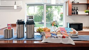 A kitchen counter with a coffee maker, thermos, fruits, and breakfast items. - The Atlantic Hotel (Southampton)