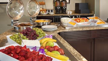 Un buffet proposant une variété de fruits, de fromages et de pains.