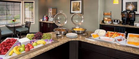 A breakfast buffet with various food items and a coffee station.