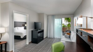A hotel room with a bed, a TV, a desk, and a view of the outdoors. - Staybridge Suites Miami Doral Area by IHG (Miami)