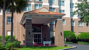 A multi-story hotel with a covered entrance and a palm tree in the foreground. - Staybridge Suites Miami Doral Area by IHG (Miami)