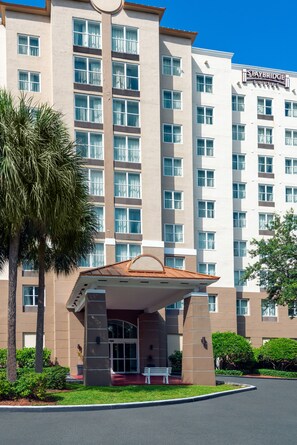 A multi-story hotel with a covered entrance and a palm tree in the foreground. - Staybridge Suites Miami Doral Area by IHG (Miami)