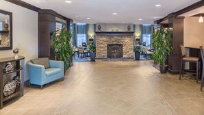 A spacious lobby with a stone fireplace, comfortable seating, and a reception area. - Sonesta ES Suites Atlanta - Perimeter Center (Atlanta)