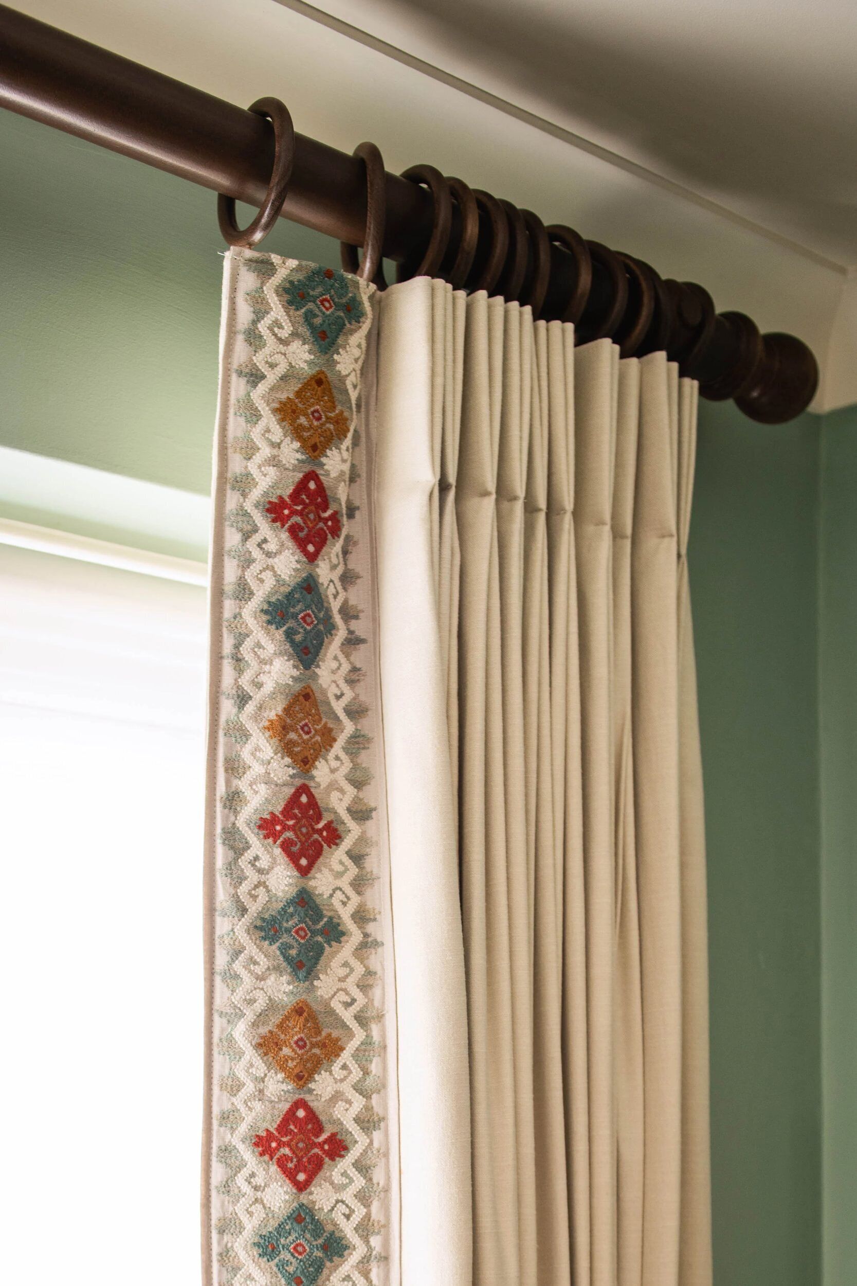 A curtain with a patterned border and a plain section.